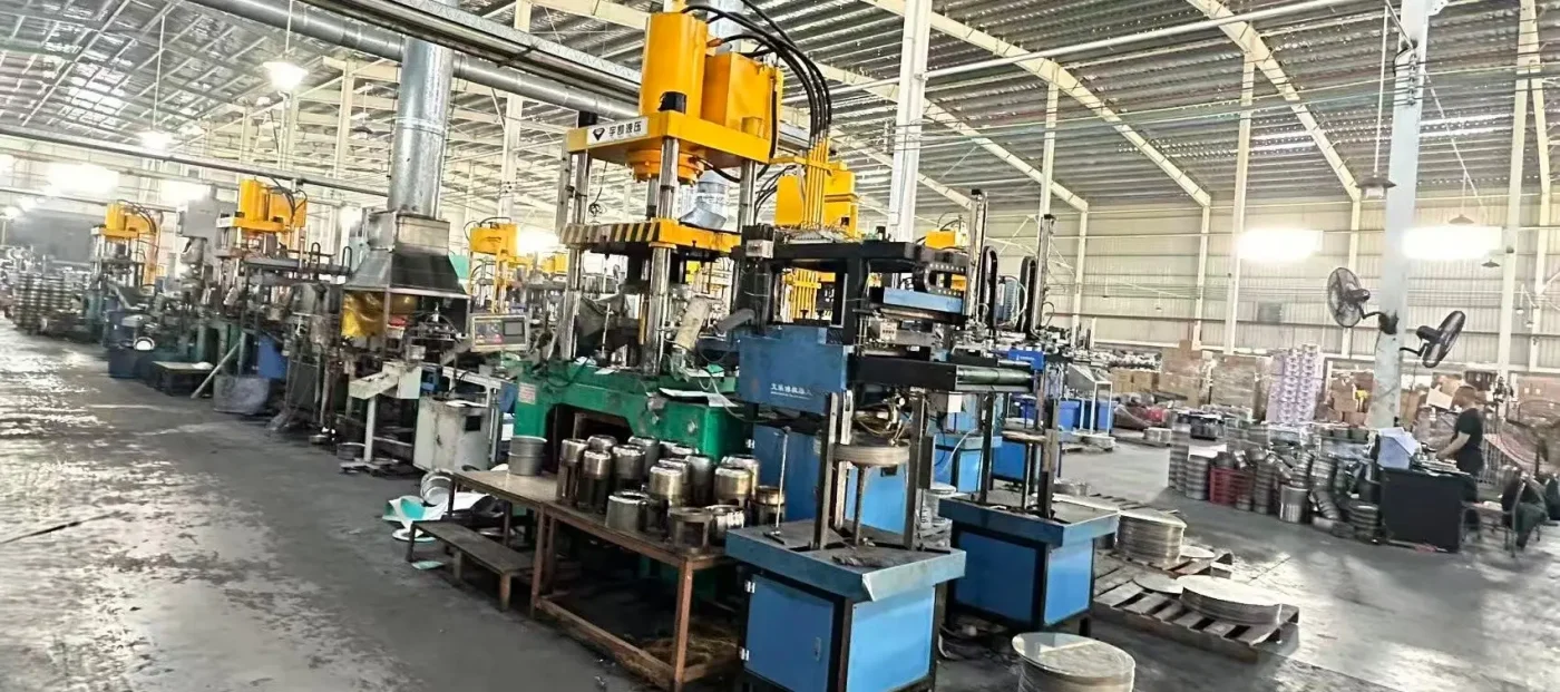 stainless steel cookware manufacturing factory floor with hydraulic presses for OEM cookware sourcing