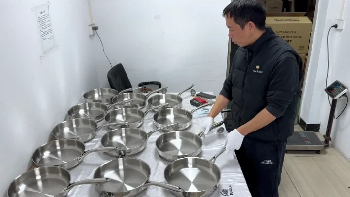 Cookware inspector checks stainless steel frying pans before bulk order release