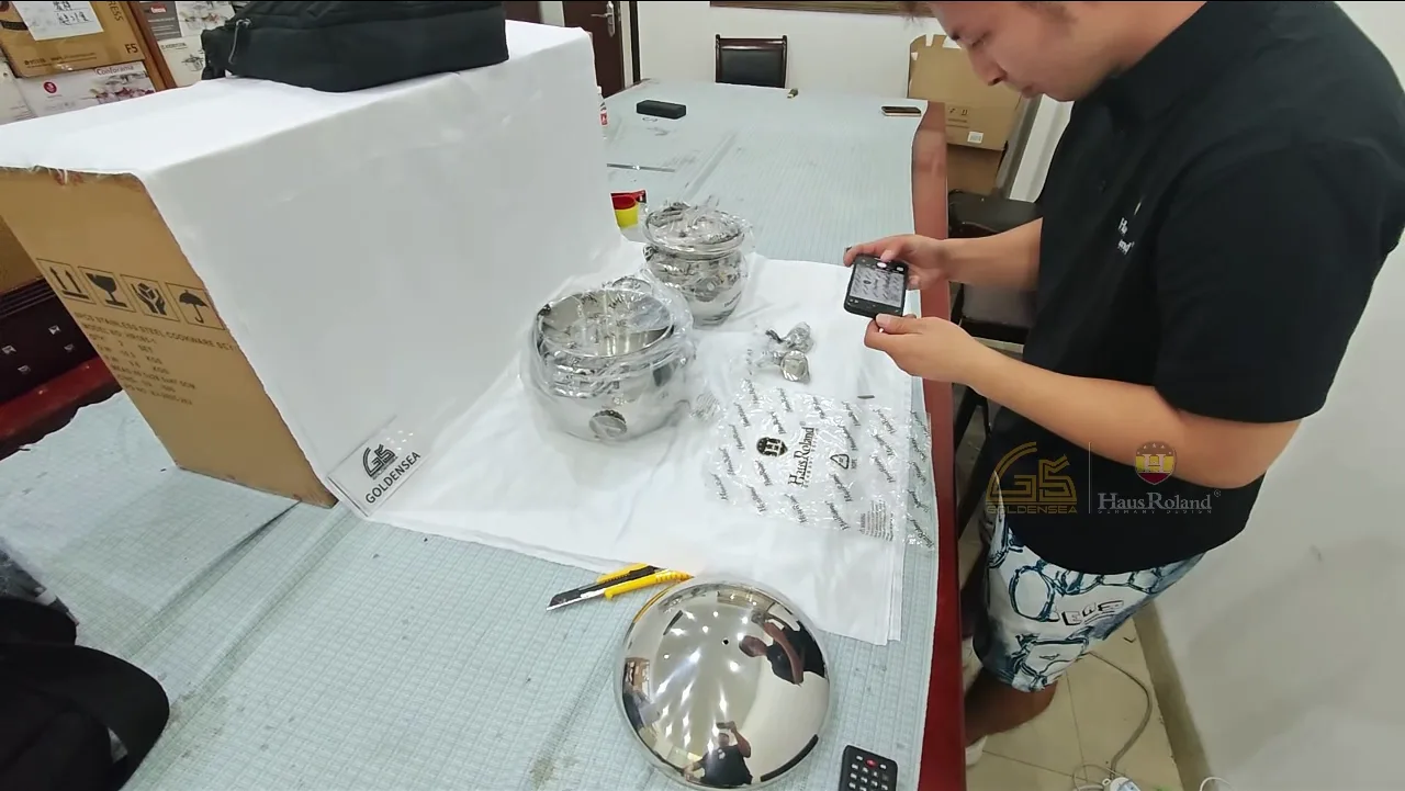 Quality inspector photographing stainless steel cookware samples and packaging for order documentation