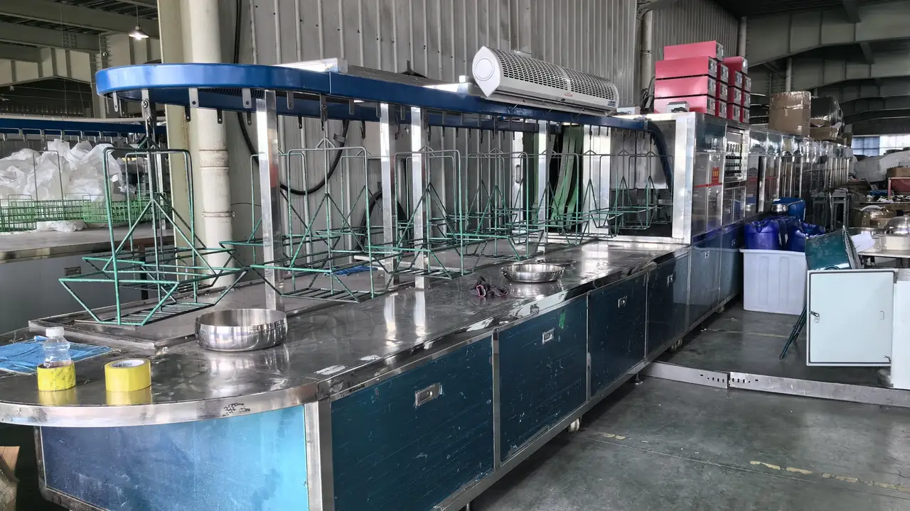 Cookware ultrasonic cleaning line with overhead transport and hanging loading racks