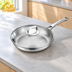 GS-01704-FP tri-ply titanium frying pan with hammered interior, glass lid and long handle on a kitchen counter