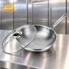 GS-01704-WK tri-ply titanium wok with hammered interior, long handle and glass lid on a kitchen counter