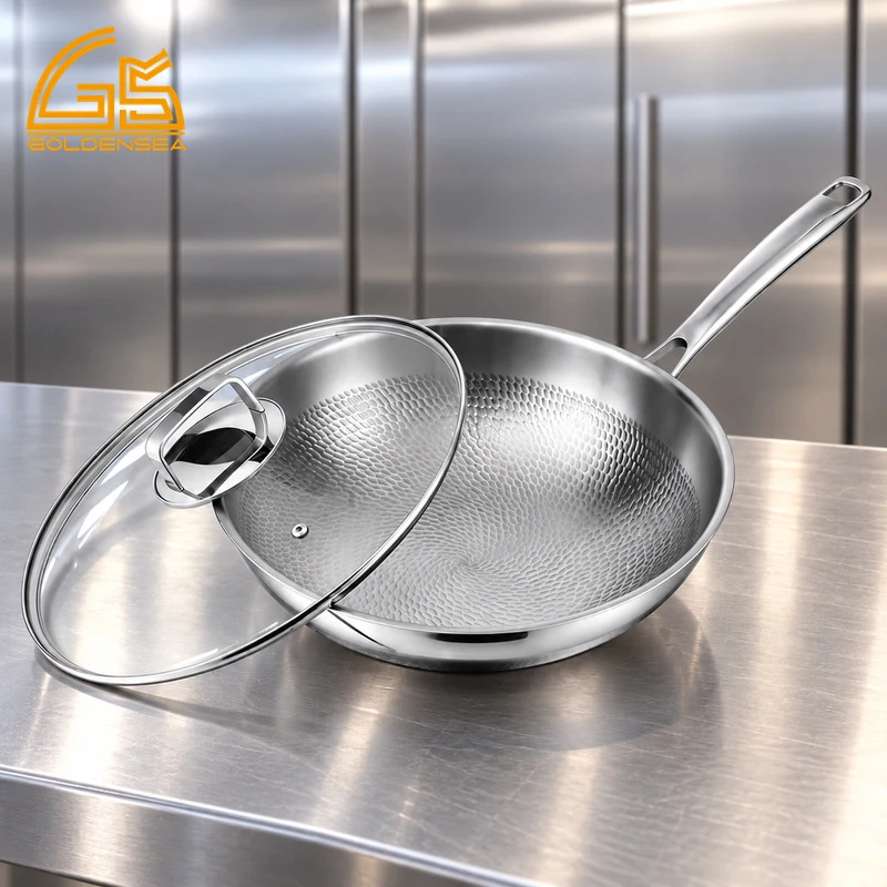 GS-01704-WK tri-ply titanium wok with hammered interior, long handle and glass lid on a kitchen counter