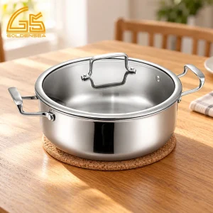 GS-01801-CA 5-ply stainless steel casserole pot with glass lid and riveted side handles on a dining table